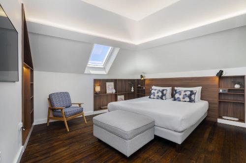 um quarto com uma cama branca e uma cadeira em Lisbon Downtown Luxury Family Residence em Lisboa