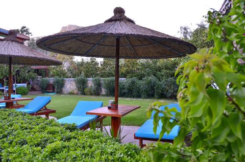 a group of chairs and tables with an umbrella at Liona Hotel & SPA in Gundogan