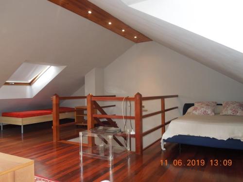 1 dormitorio con cama y mesa en el ático en La casa de Clara Puente Arce, en Arce