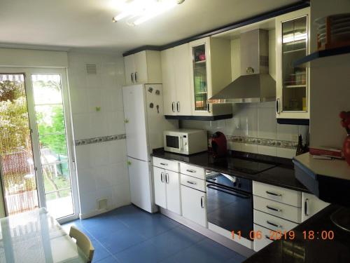 a kitchen with a white refrigerator and a microwave at La casa de Clara Puente Arce in Arce