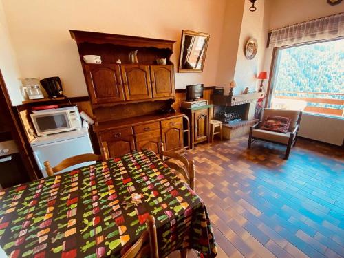 un salon avec une table et une cuisine dans l'établissement 2 pièces cabine sans prétention avec balcon et parking - FR-1-459-47, à La Clusaz