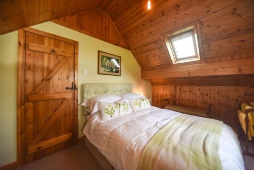 a bedroom with a bed and a window and a door at Clays View Alstonefield in Alstonfield