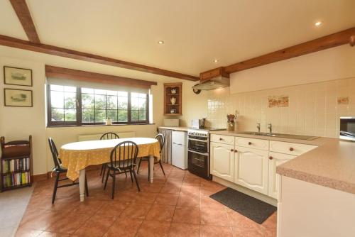 a kitchen with a table and chairs in a kitchen at Clays View Alstonefield in Alstonfield