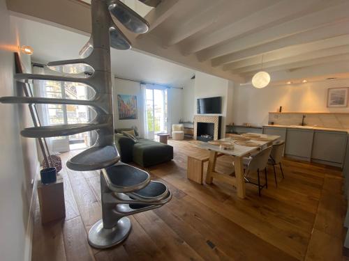 een wenteltrap in een woonkamer met een tafel bij Loft Cathédrale in Bayonne