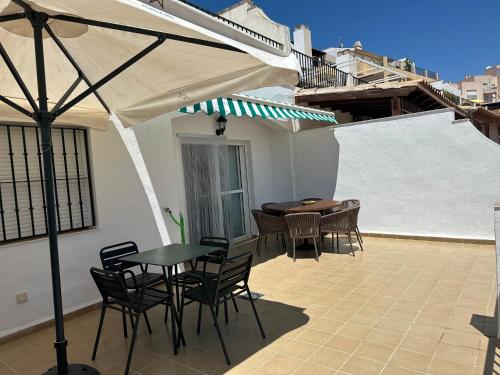 un patio avec une table, des chaises et un parasol dans l'établissement San Juan de los Terreros Mª S, à San Juan de los Terreros