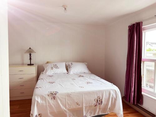 um quarto com uma cama, uma cómoda e uma janela em Chez moi em Montmagny