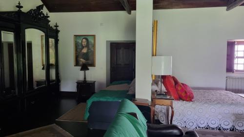 a bedroom with a bed and a couch and a mirror at Quinta do Sanguinhal in Rio Maior