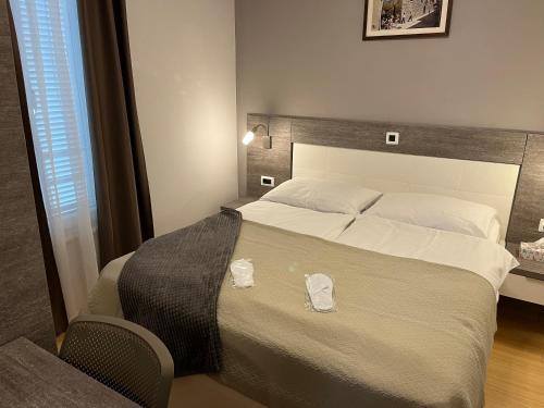 1 dormitorio con 1 cama grande y 2 toallas. en Sunny apartman u resortu, Petrčane, apartman za 4, AKCIJA! en Petrcane