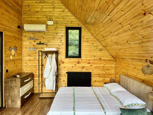 a bedroom with a bed in a wooden cabin at WOOD HOUSE LAGODEKHI in Lagodekhi