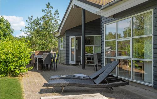 a patio with a chair and a table on a house at Beautiful Home In Væggerløse With Sauna in Bøtø By