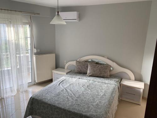 a bedroom with a bed and a large window at Τhe Sunny Apartments in Igoumenitsa