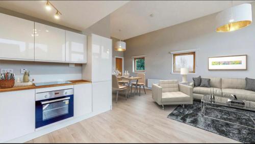 uma cozinha e sala de estar com um sofá e uma mesa em Stylish Ensuite in Maryhill em Maryhill