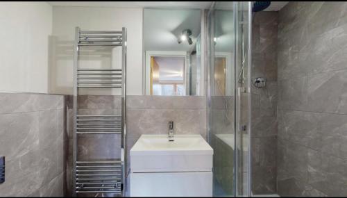 uma casa de banho com um lavatório, um chuveiro e um espelho. em Stylish Ensuite in Maryhill em Maryhill