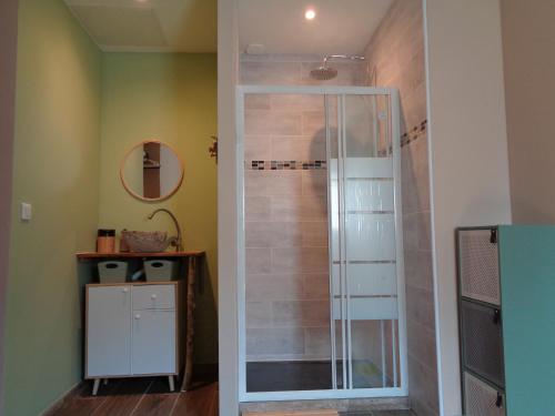 a shower with a glass door in a bathroom at Au soleil couchant in Villemoustaussou