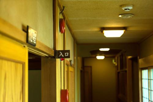 a hallway with a sign on the side of a building at Kyo no Minshuku Ohara no Sato in Kyoto