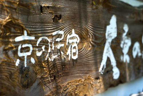 a piece of wood with white writing on it at Kyo no Minshuku Ohara no Sato in Kyoto