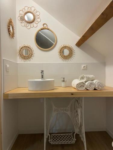 a bathroom with a sink and mirrors on the wall at L’escapade de Tali in Talizat