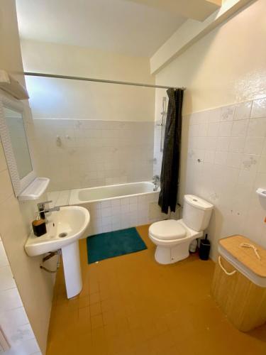 a bathroom with a toilet and a sink and a tub at Appartement: Dakar-Plateau in Dakar