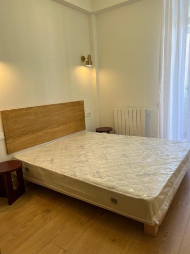a large bed in a room with a wooden floor at Eka's apartment in Tbilisi City