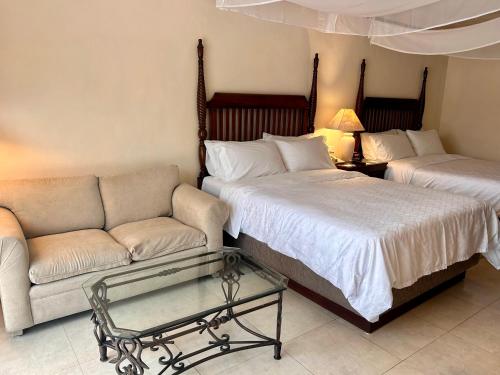 a living room with two beds and a couch at Holiday Inn Merida by IHG in Mérida