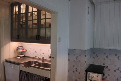 una cocina con fregadero y un espejo encima. en Cozy family house, en Tromsø
