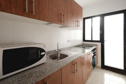 una cucina con lavandino e forno a microonde di Apartamento Domínguez, Fuerteventura a Morro del Jable