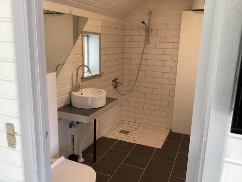 y baño con lavabo, ducha y aseo. en Feriehus - Marielyst centrum en Bøtø By