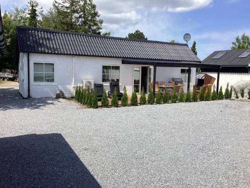 a white house with a sheep standing in front of it at Feriehus - Marielyst centrum in Marielyst
