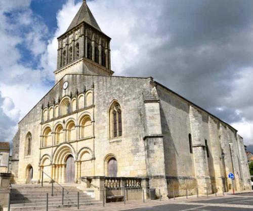 a large building with a tower on top of it at Superbe duplex cœur de ville 3 étoiles in Jonzac