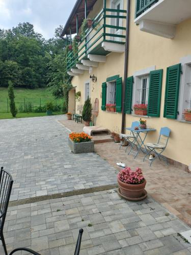a courtyard of a house with chairs and flowers at Casa relax immersa nel verde della natura in Casalborgone