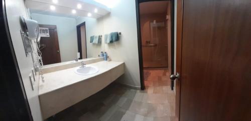 a bathroom with a sink and a large mirror at Suite Akros in Quito