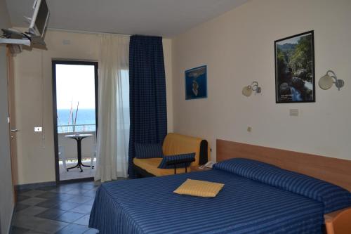 a bedroom with a bed and a view of the ocean at Hotel Jonic in Portopalo