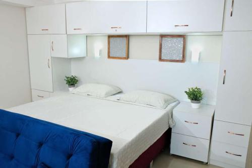 um quarto com uma cama branca e uma cadeira azul em Tropical Executive 1305 with VIEW em Manaus