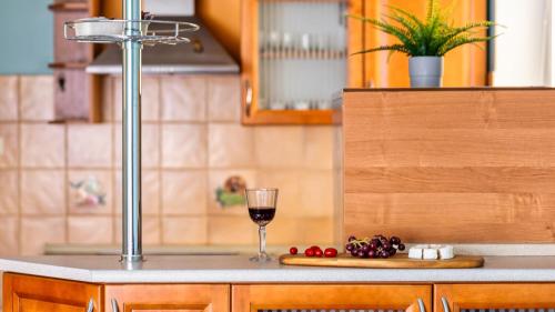 a glass of wine sitting on top of a kitchen counter at Teleexpresu Apartamenty PIAMOLA in Krynica Morska