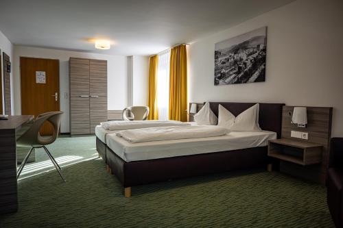 a hotel room with a bed and a desk at Hotel Grüner Baum in Bühlertal