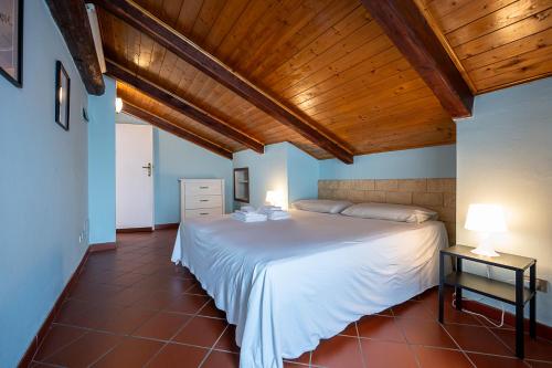 a bedroom with a white bed and a wooden ceiling at San Luigi Apartment 2.0 in Beinasco