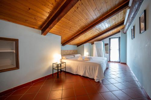 1 dormitorio con cama blanca y techo de madera en San Luigi Apartment 2.0, en Beinasco