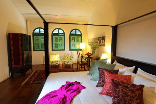 喬治市的住宿－咖啡畫室酒店，卧室配有一张带彩色枕头的大型白色床。