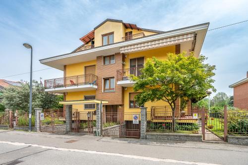 a yellow house with a fence in front of it at San Luigi Apartment 2.0 in Beinasco