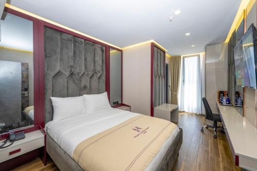 een hotelkamer met een groot bed en een televisie bij Heaven Premium Hotel İstanbul Airport in Arnavutköy