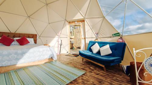 Una habitación con una cama y una silla en una tienda de campaña en Andes Glamping, en Guatavita