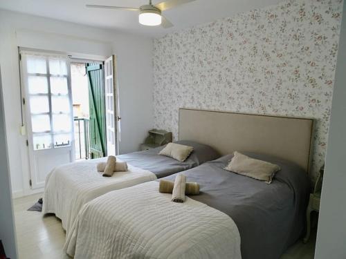 2 camas individuales en un dormitorio con ventana en Villa Familiar con encanto en Hondarribia