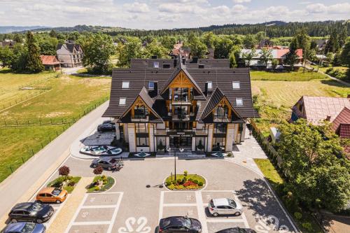 an aerial view of a large house with cars parked in a parking lot at Aparthotel Góralski Spa 2 in Białka Tatrzanska