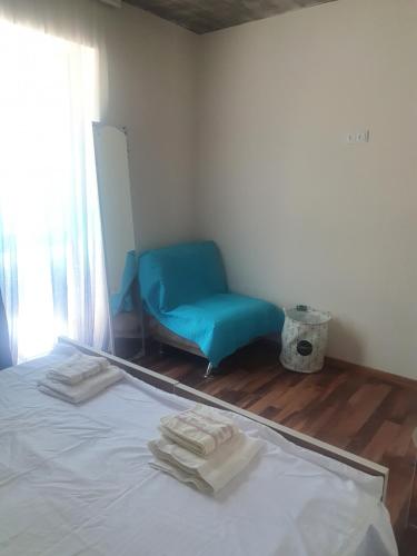 a bedroom with a bed and a blue chair at Racha - ABA in Ambrolauri
