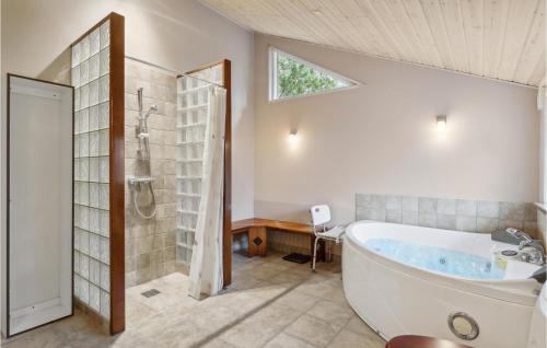 La salle de bains est pourvue d'une baignoire, d'une douche et d'un lavabo. dans l'établissement Amazing Home In lbk With Kitchen, à Ålbæk