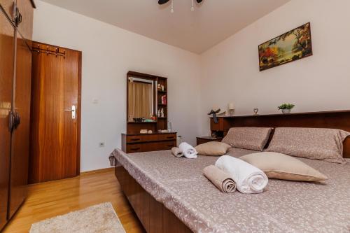 1 dormitorio con 1 cama con toallas en Luka, en Kaštela