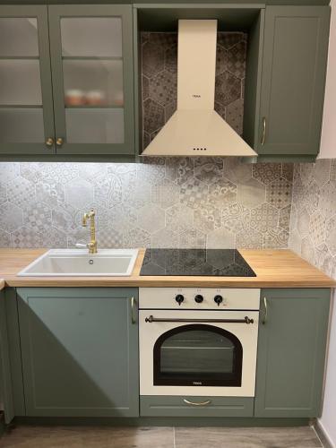 a kitchen with a sink and a stove at Loutraki apARTment in Loutraki