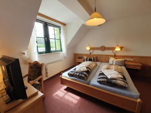 a bedroom with two beds and a tv in it at Hotel Stadt Olbernhau in Olbernhau