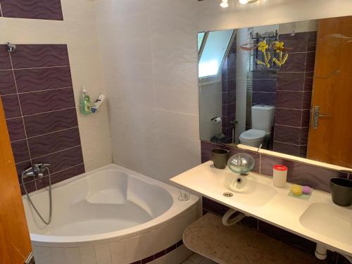 ein Bad mit einer Badewanne, einem Waschbecken und einer Dusche in der Unterkunft Perfect family vacation house in King Mariout