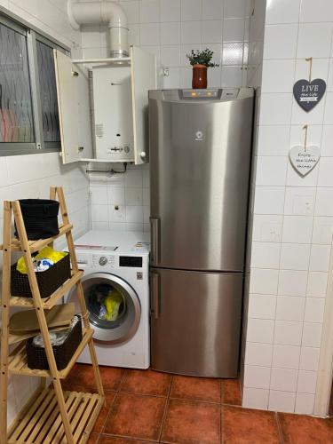 a kitchen with a refrigerator and a washing machine at Casa Montigar in Chiclana de la Frontera